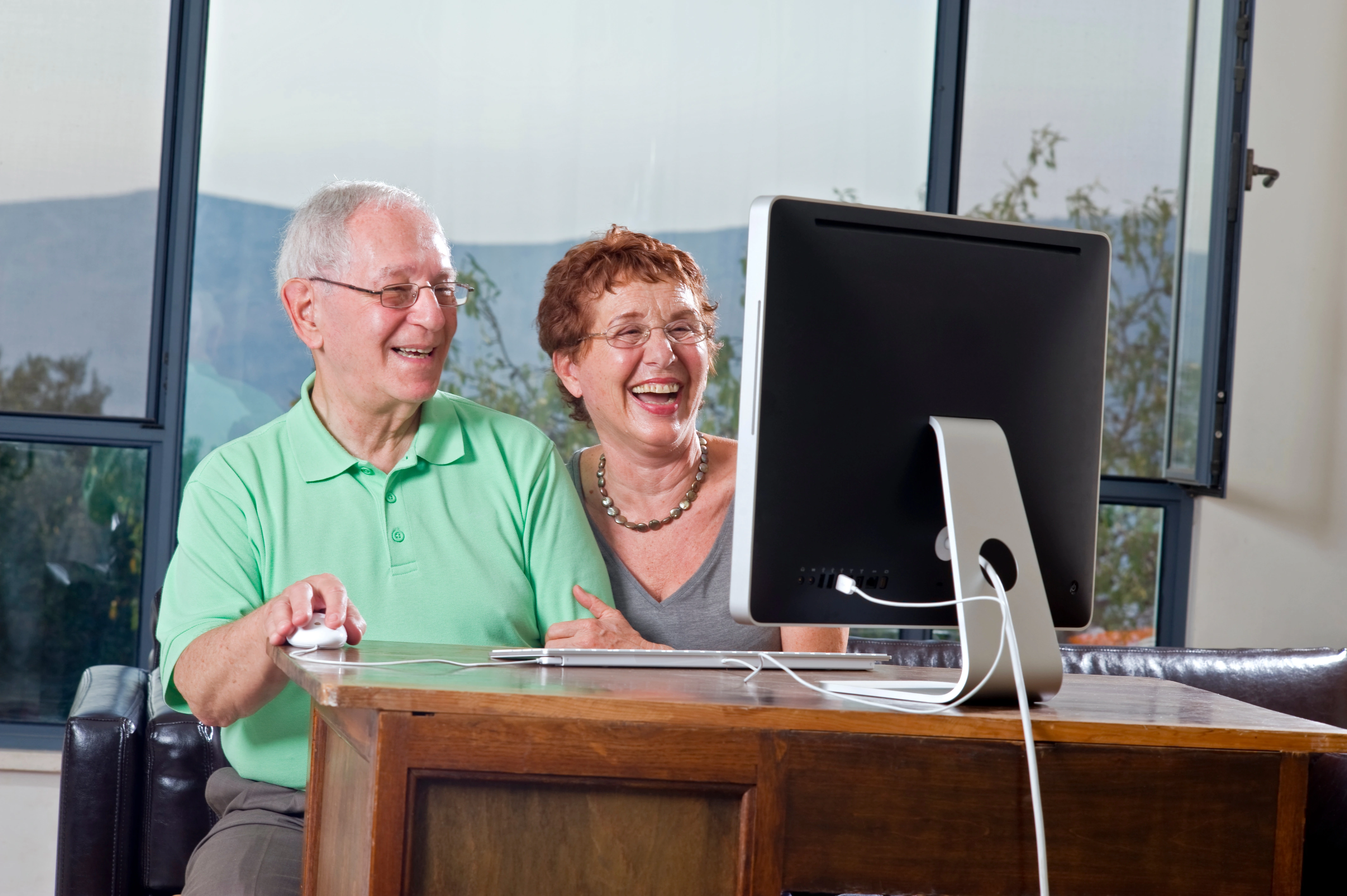 Older couple working together on a legacy machine, symbolizing experience and technology